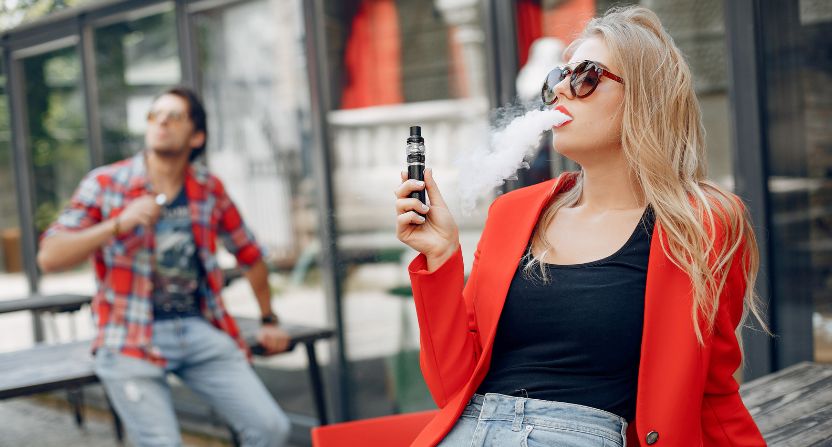 Femme qui vapote dehors